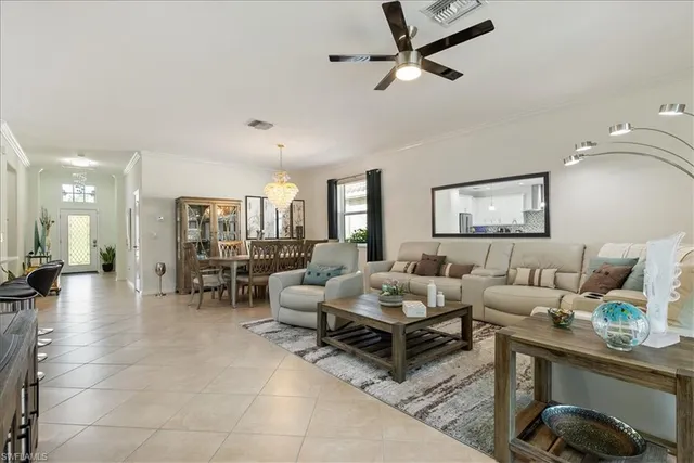 a living room with furniture kitchen view and a large window