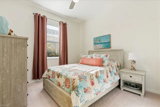 a bedroom with a bed and a lamp on dresser