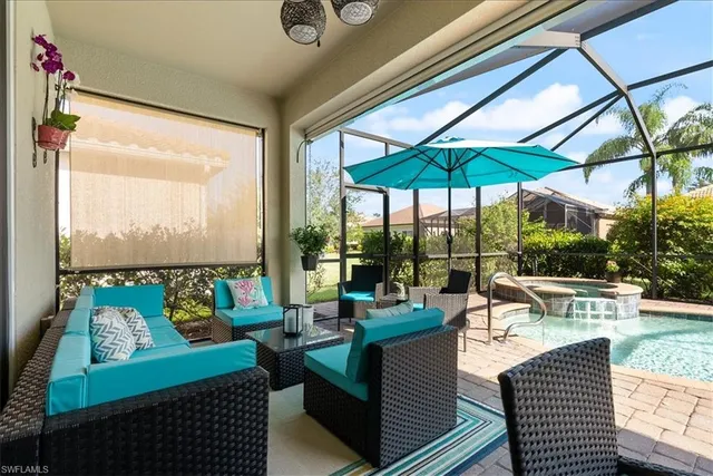 an outdoor living room with patio furniture and a floor to ceiling window