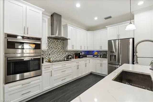 a kitchen with white cabinets and stainless steel appliances