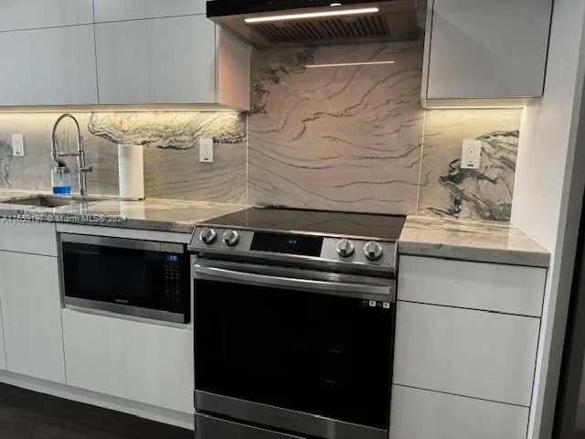 a kitchen with stainless steel appliances a sink and wooden cabinets