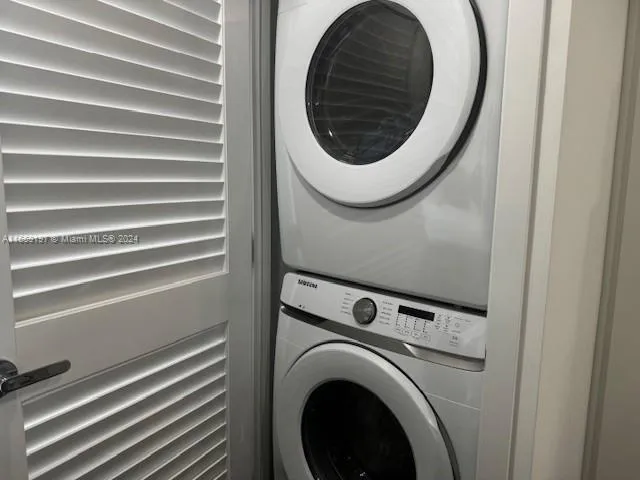 a view of kitchen and empty room with wooden floor