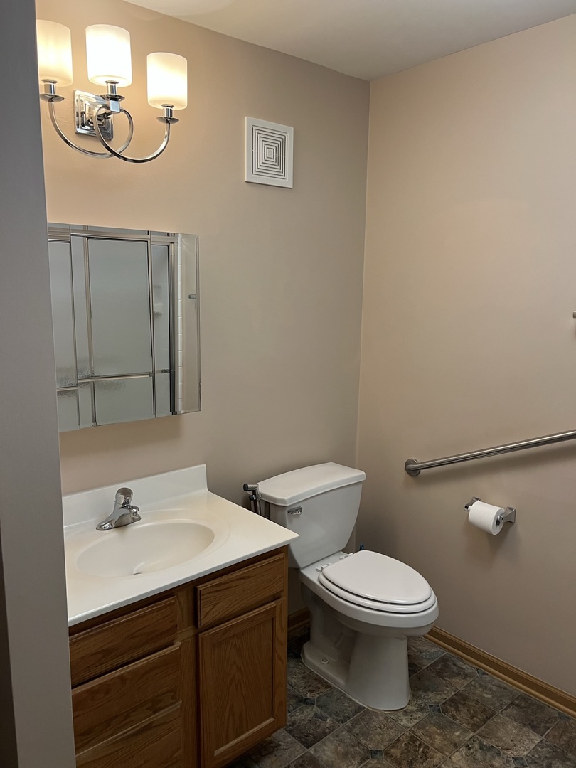 801 North McLean Boulevard, Unit 226 Elgin, IL 60123 - Photo 9 of 19 a bathroom with a toilet a sink and mirror