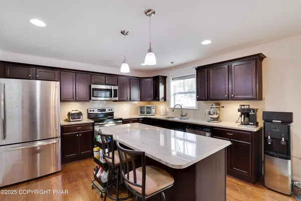 a kitchen with stainless steel appliances granite countertop a sink stove and microwave