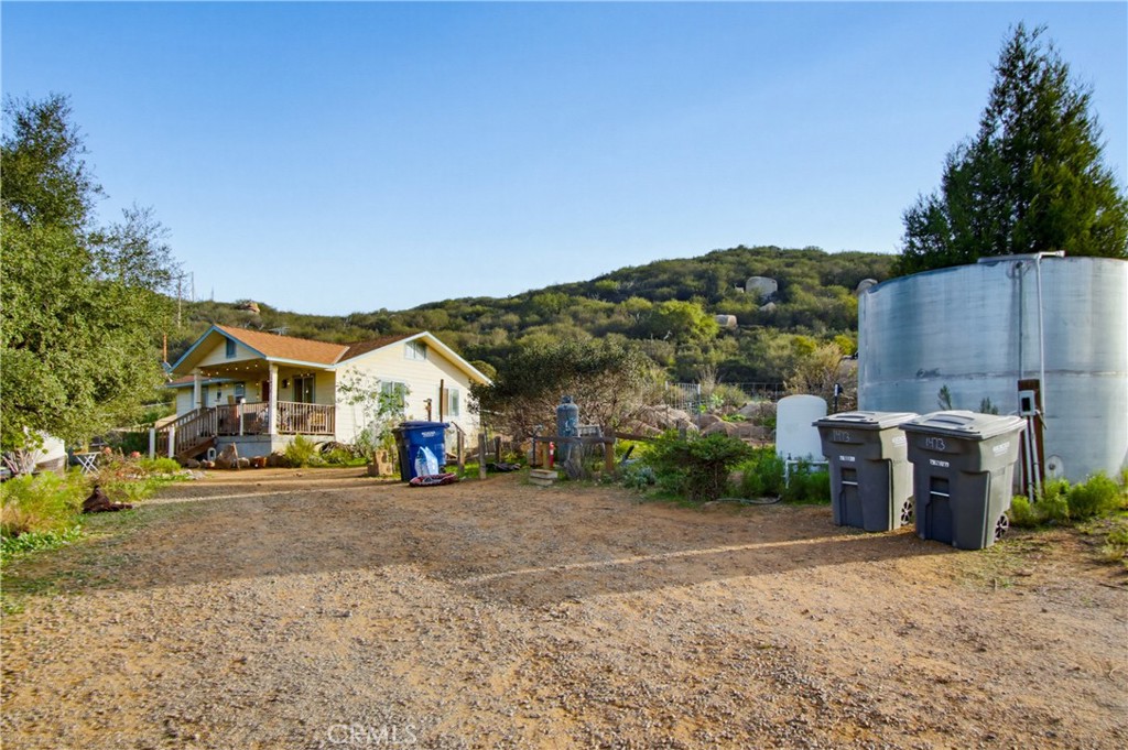 1473 Arnoldo Road Dulzura, CA 91917 - Photo 17 of 19 a view of a house with a yard and parking space