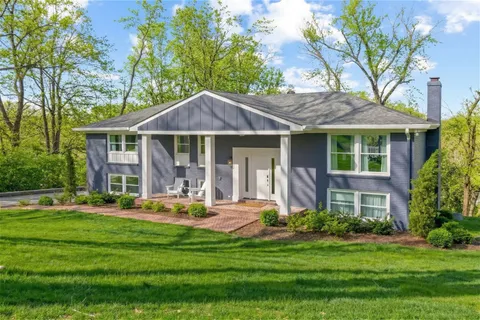 a front view of a building with a garden and plants