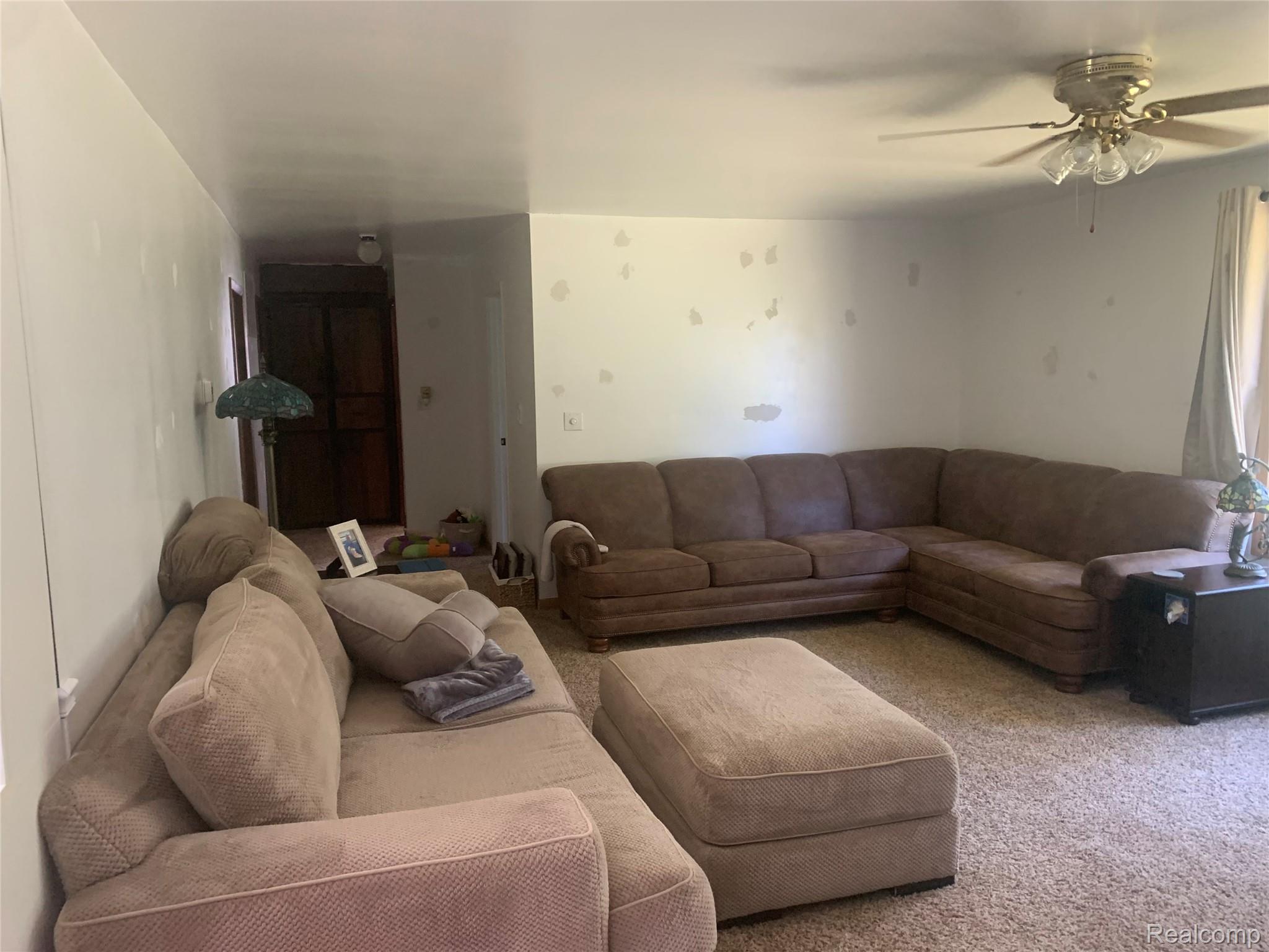 3494 Castle Road North Branch, MI 48461 - Photo 11 of 22 Carpeted living space featuring a ceiling fan with light fixture and a hallway entry