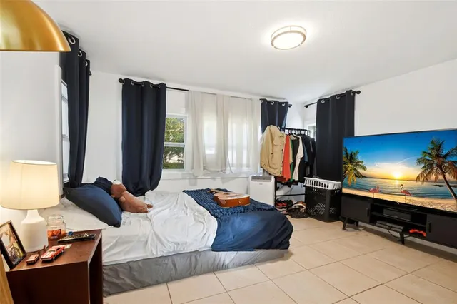 a living room with furniture a flat screen tv and a large window