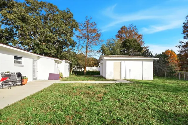 a view of a house with a big yard and large tree