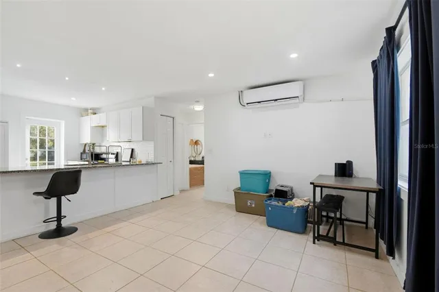 a living room with furniture and a view of kitchen