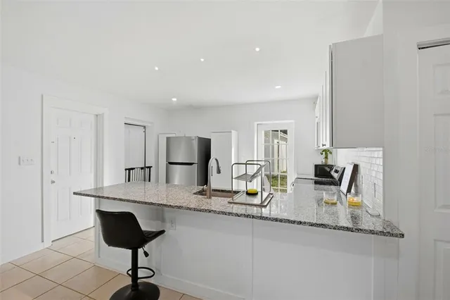 a kitchen with granite countertop cabinets and chairs