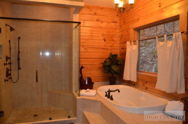 495 Mulberry Mountain Road Boone, NC 28607 - Photo 7 of 36 a bathroom with a tub a window and shower