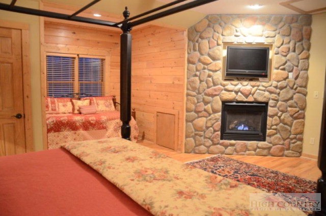 495 Mulberry Mountain Road Boone, NC 28607 - Photo 8 of 36 a living room with a fireplace and a flat screen tv