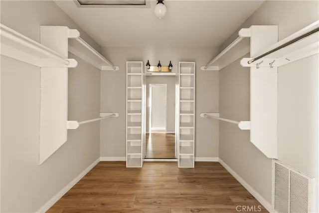 a view of a hallway with wooden floor and closet