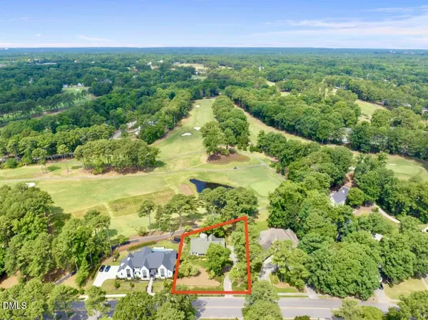 an aerial view of residential houses with outdoor space and trees