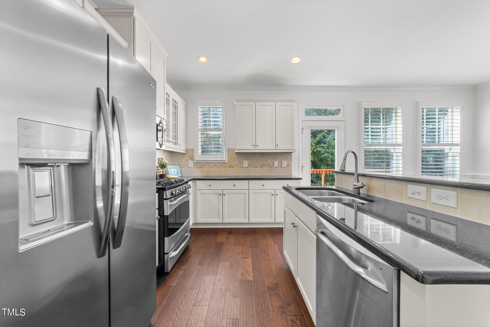 5627 Wade Park Boulevard Raleigh, NC 27607 - Photo 10 of 44 a kitchen with stainless steel appliances granite countertop a sink a stove a refrigerator and cabinets