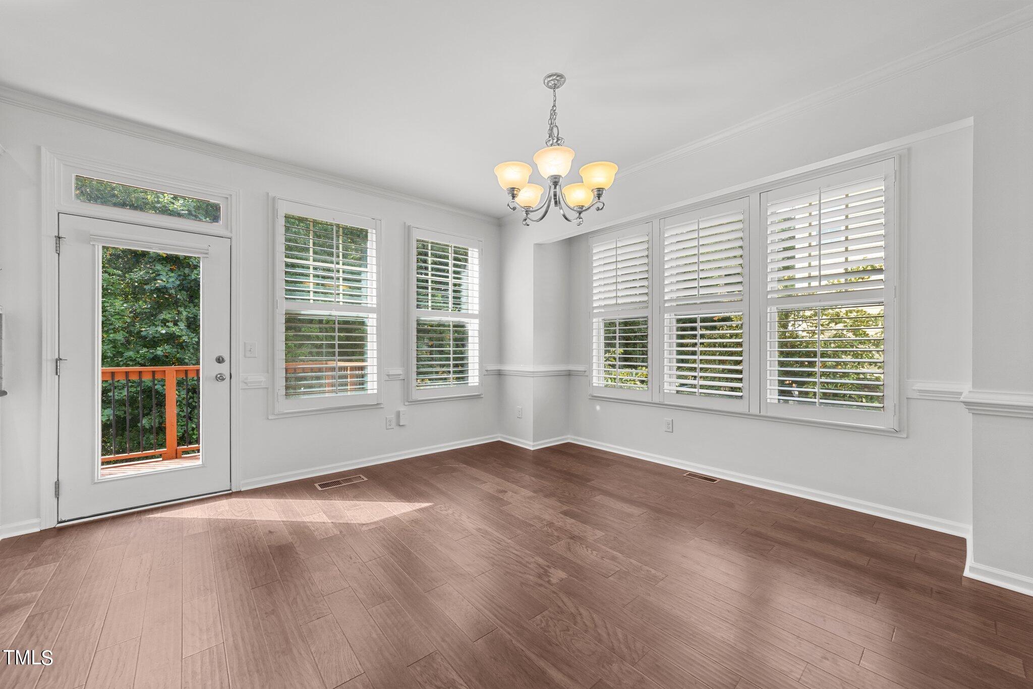 5627 Wade Park Boulevard Raleigh, NC 27607 - Photo 12 of 44 a view of an empty room with a window and wooden floor
