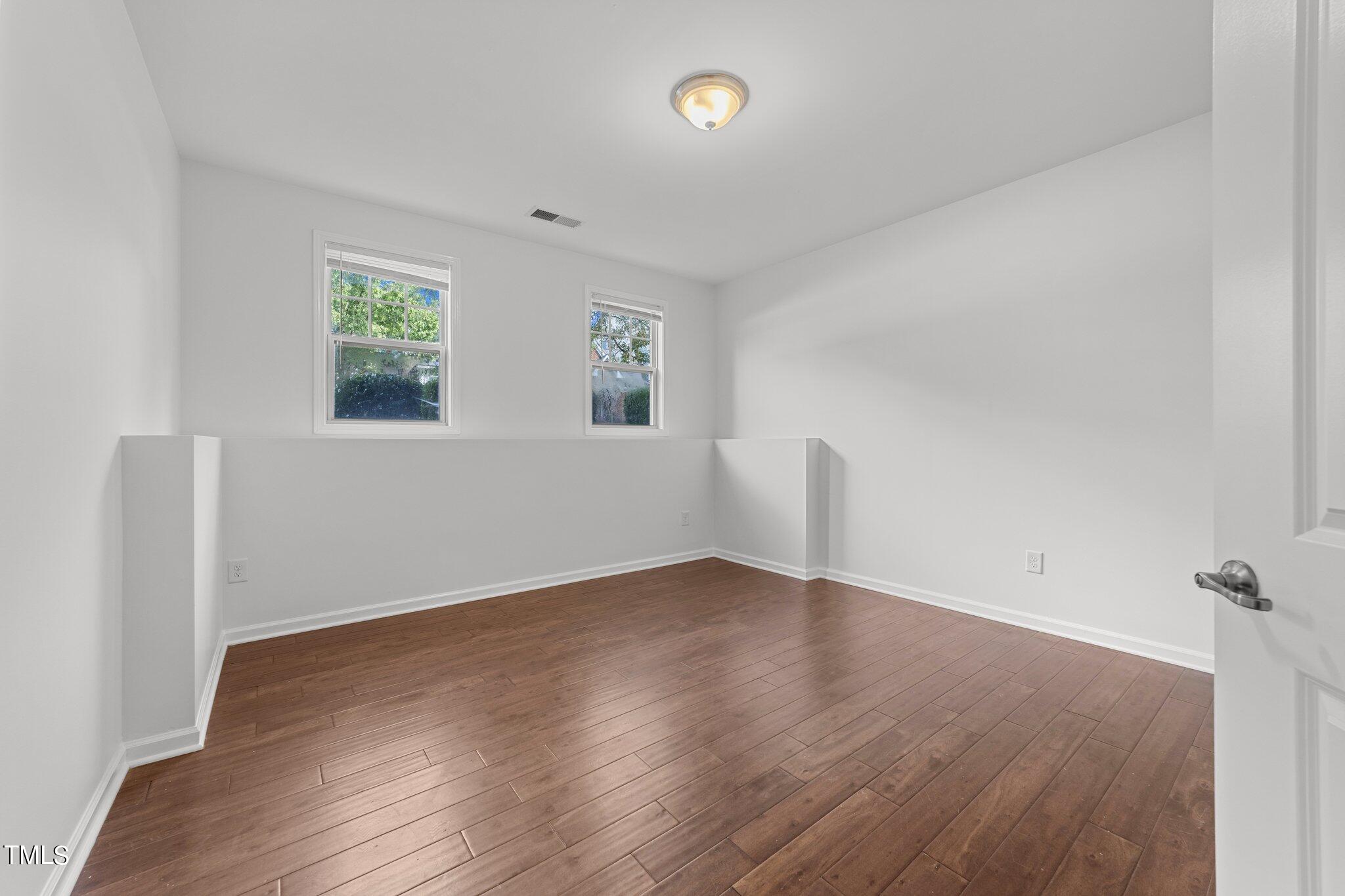 5627 Wade Park Boulevard Raleigh, NC 27607 - Photo 20 of 44 an empty room with wooden floor and windows