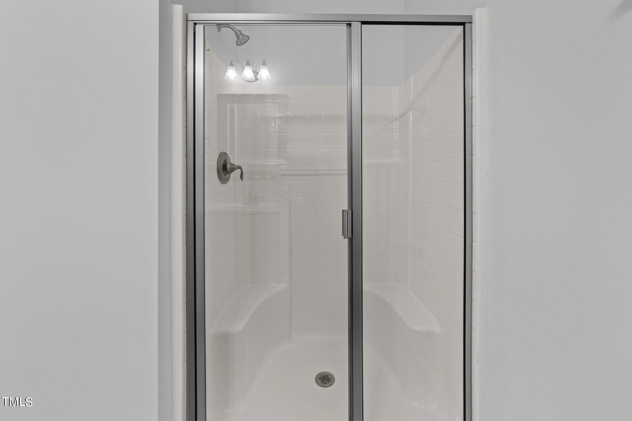 5627 Wade Park Boulevard Raleigh, NC 27607 - Photo 23 of 44 a bathroom with a glass shower door