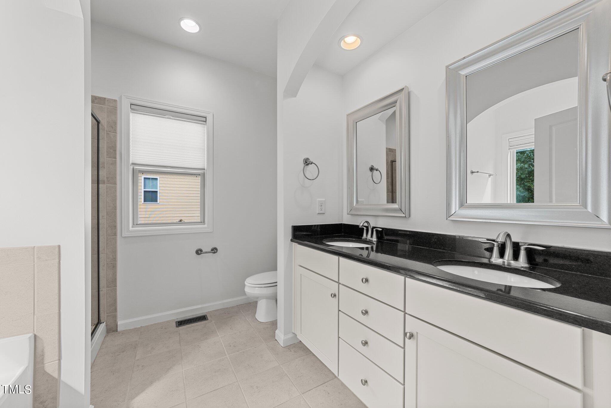 5627 Wade Park Boulevard Raleigh, NC 27607 - Photo 27 of 44 a bathroom with double sink and a mirror