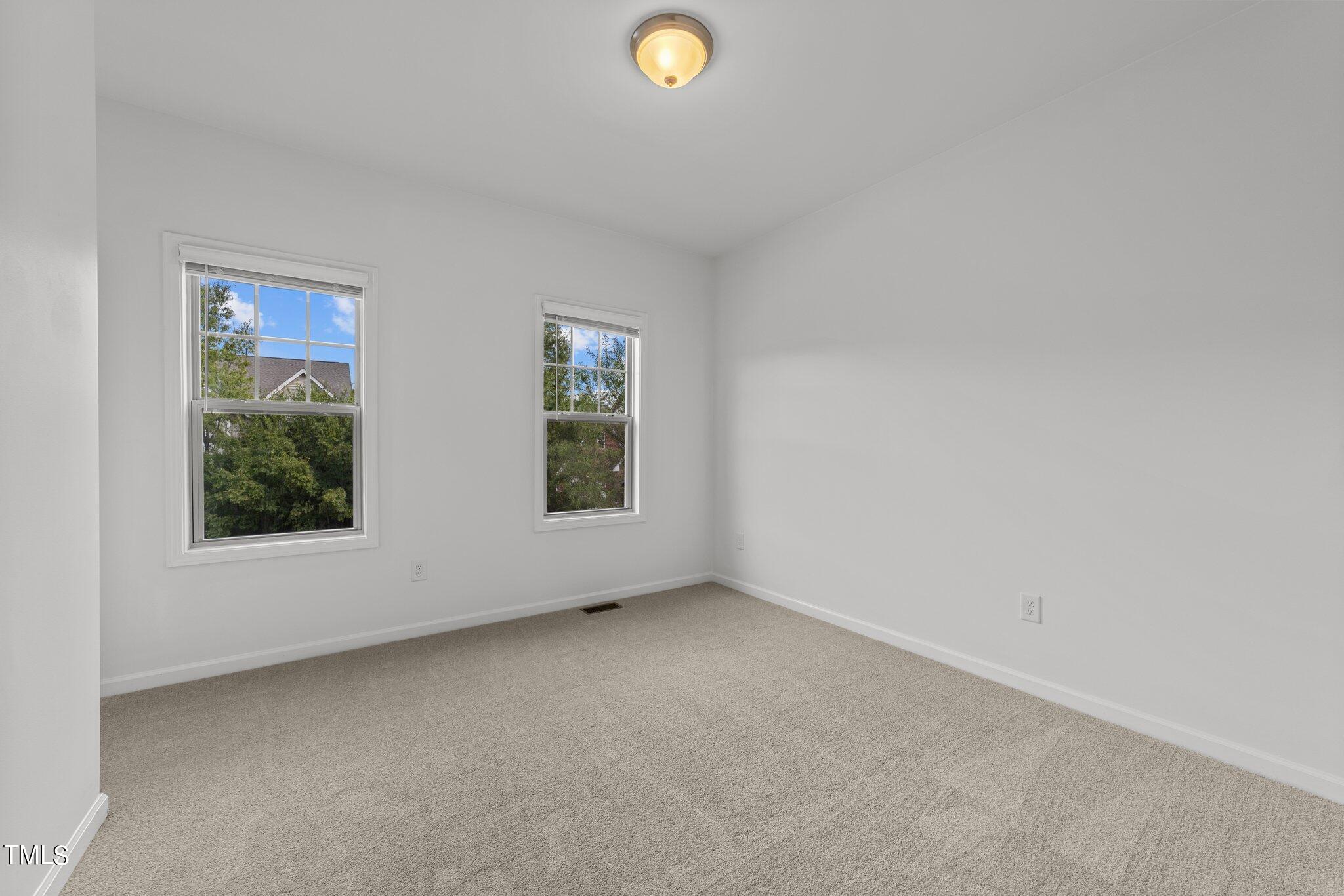 5627 Wade Park Boulevard Raleigh, NC 27607 - Photo 35 of 44 an empty room with windows and mirror