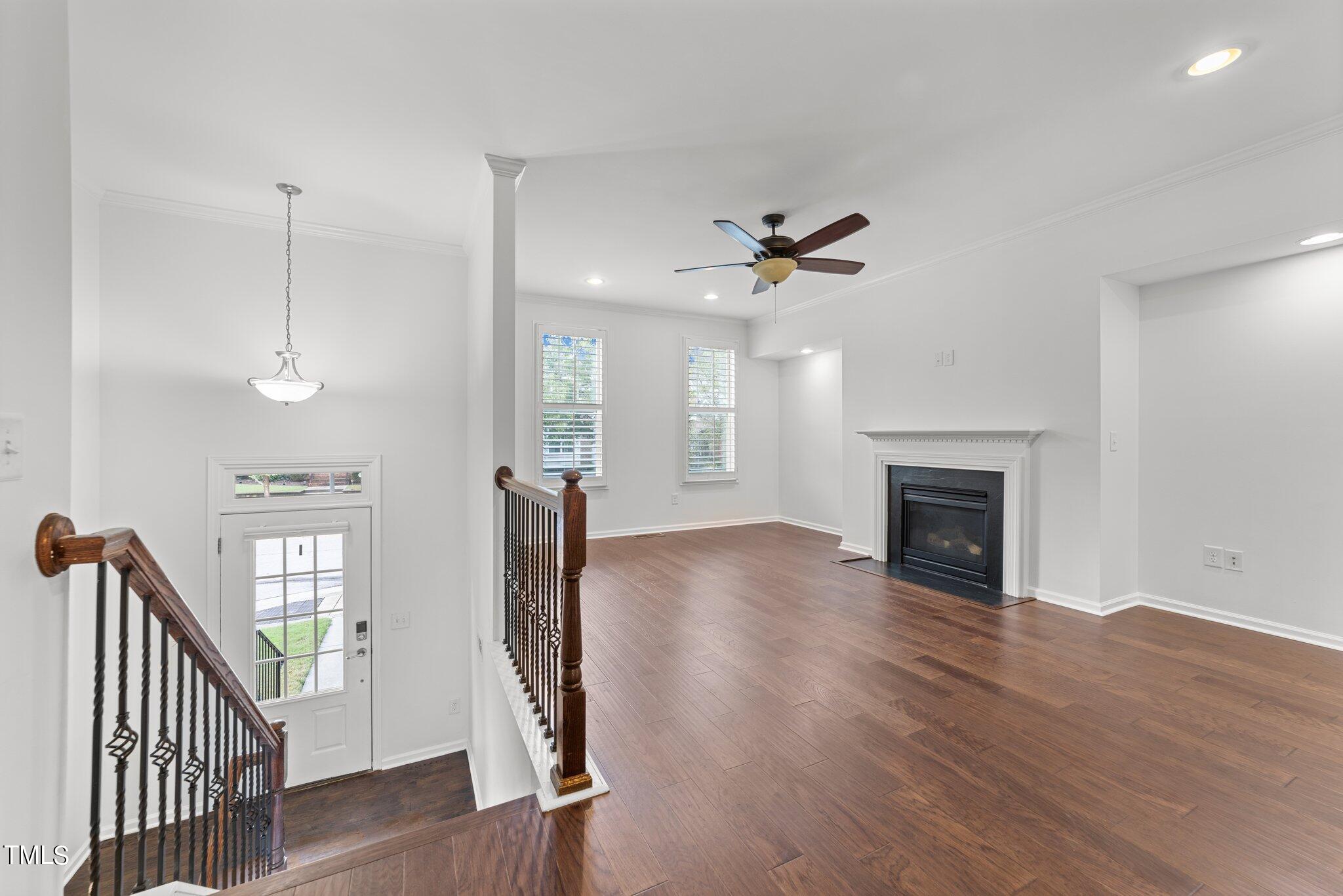 5627 Wade Park Boulevard Raleigh, NC 27607 - Photo 6 of 44 a view of an empty room with wooden floor and a fireplace
