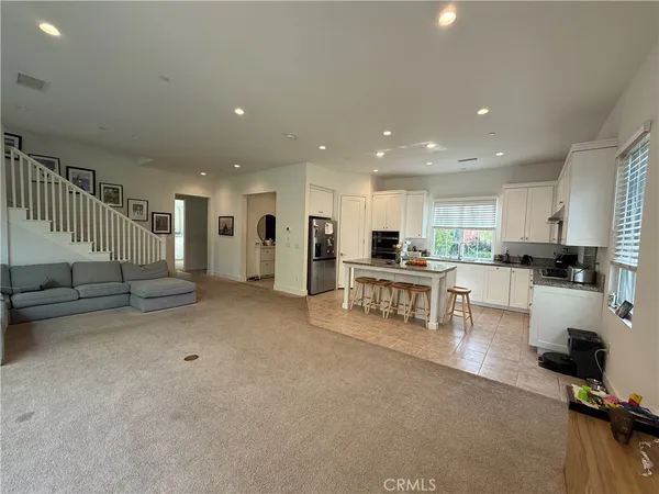 a living room with furniture and kitchen view