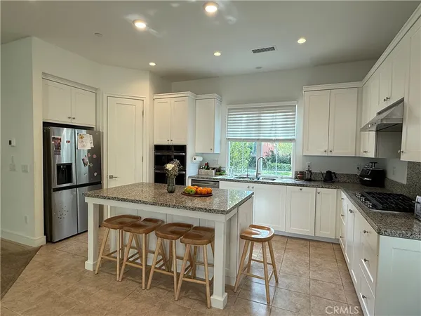 a kitchen with stainless steel appliances granite countertop a stove a sink a microwave and a refrigerator