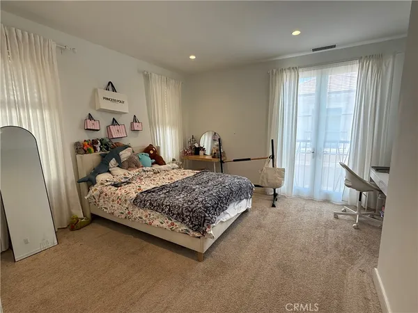 a bedroom with a large bed and a chandelier