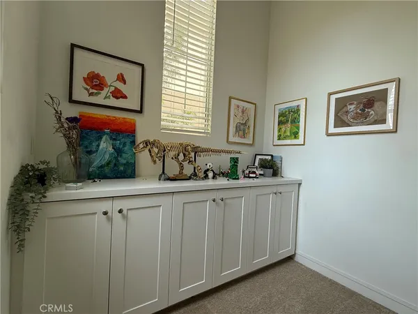 a view of a workspace with furniture and a window