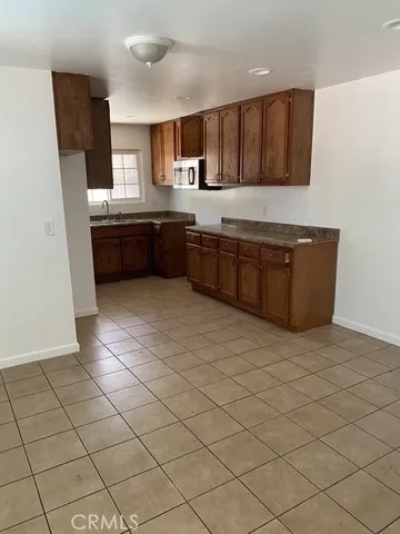 a kitchen with stainless steel appliances a sink a stove top oven a counter space and cabinets