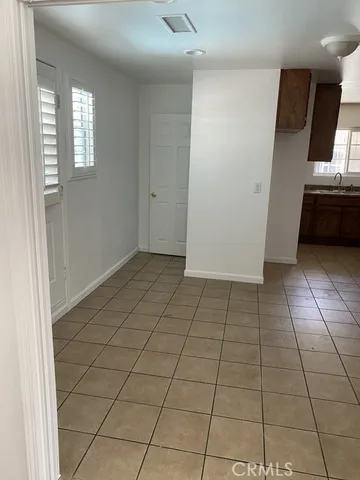 a view of a livingroom with an empty space and a kitchen