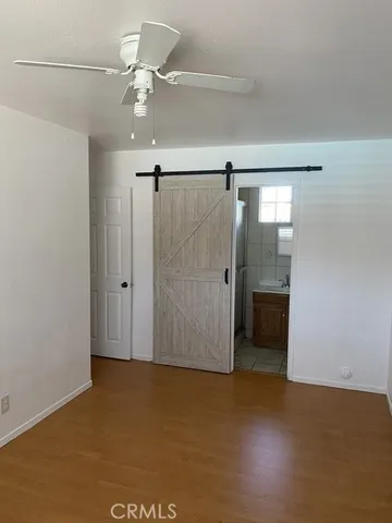 a view of a room with a ceiling fan and closet area