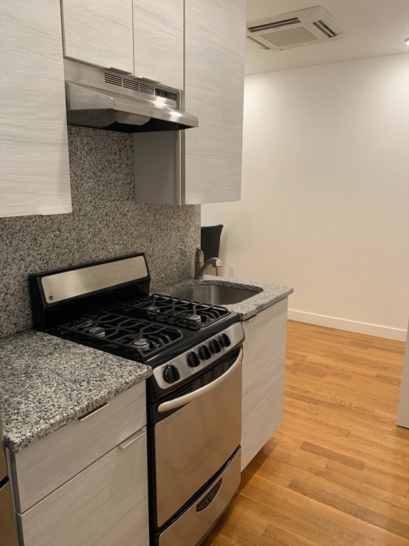 21 5th Street, Unit 1 Chelsea, MA 02150 - Photo 2 of 10 a stove top oven sitting inside of a kitchen