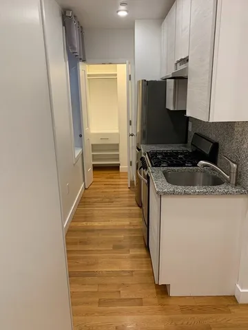 a kitchen with granite countertop a sink and a stove top oven