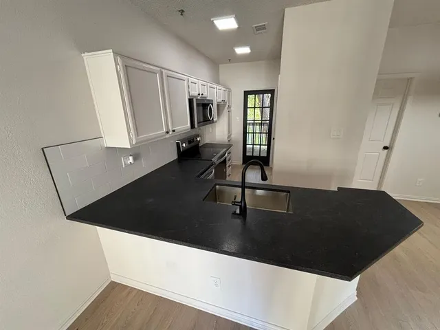 a kitchen with a sink and white cabinets