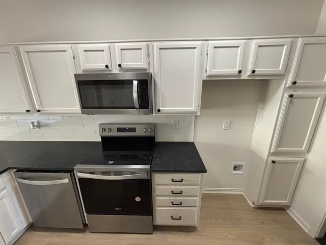 a kitchen with stainless steel appliances a stove microwave and refrigerator