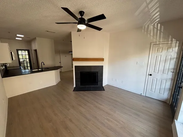 an empty room with wooden floor and a fireplace
