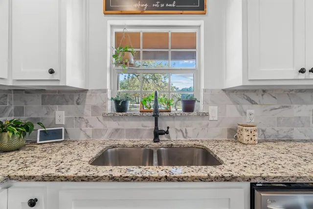 a kitchen with granite countertop a sink and a window