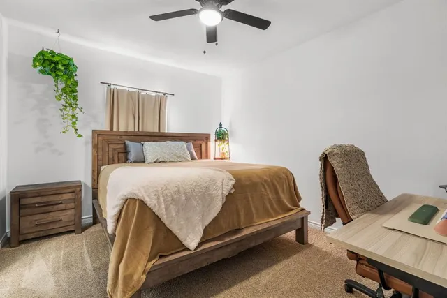 a bedroom with a bed a chandelier and a dresser
