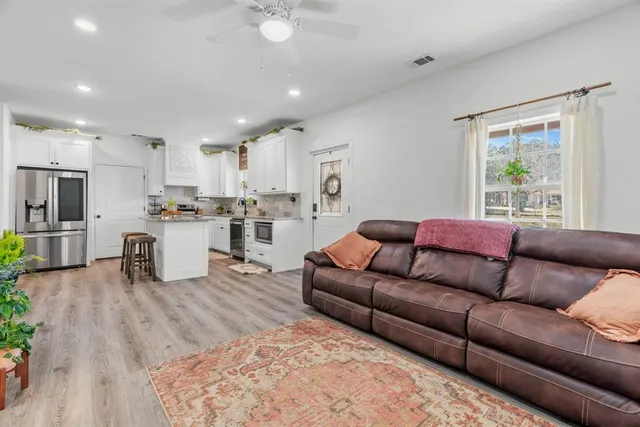 a living room with furniture and kitchen view