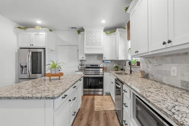 a kitchen with stainless steel appliances granite countertop a sink stove and refrigerator