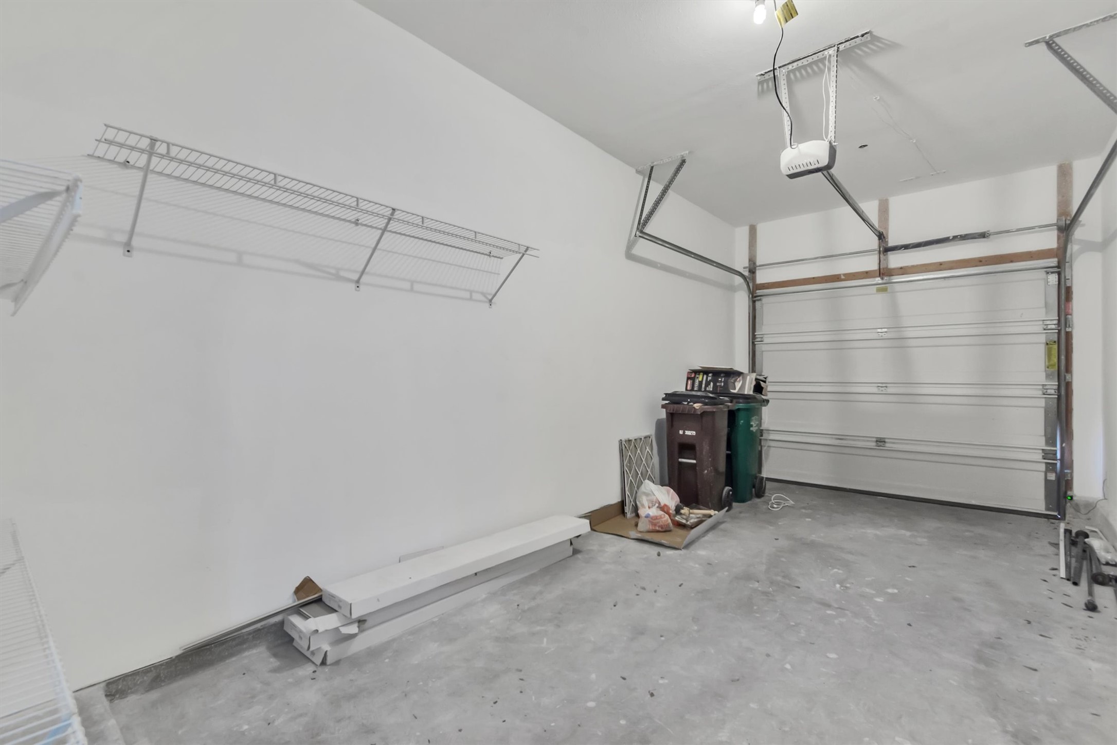14815 Avery Ranch Boulevard, Unit 2A Austin, TX 78717 - Photo 21 of 27 A well-lit garage featuring ample wall shelving and a modern overhead door.