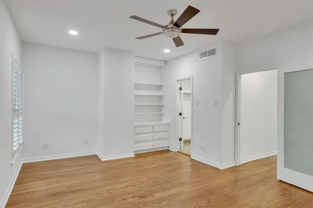 wooden floor in an empty room with a ceiling fan