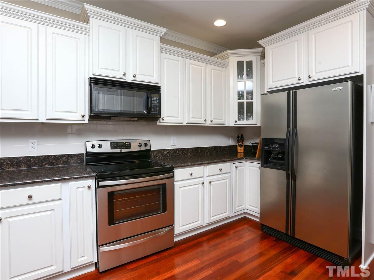 2220 Karns Place Raleigh, NC 27614 - Photo 4 of 25 a kitchen with stainless steel appliances white cabinets a sink and a refrigerator
