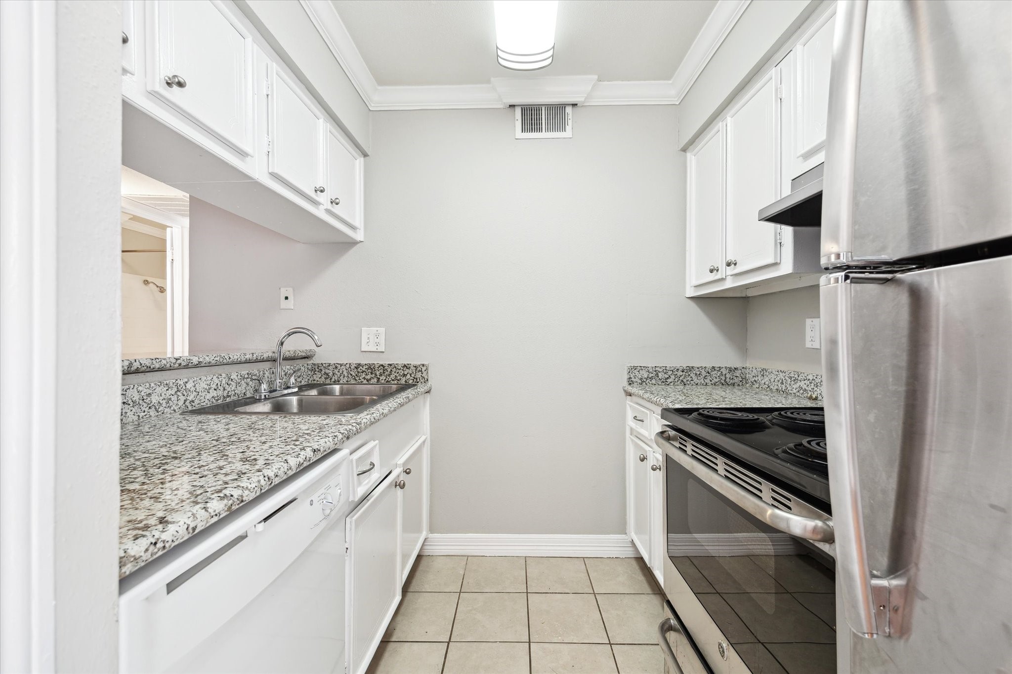 a kitchen with granite countertop a sink stove and cabinets