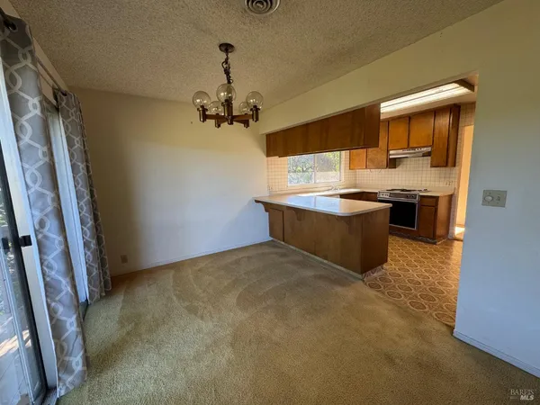 a view of kitchen with stainless steel appliances granite countertop stove top oven and cabinets