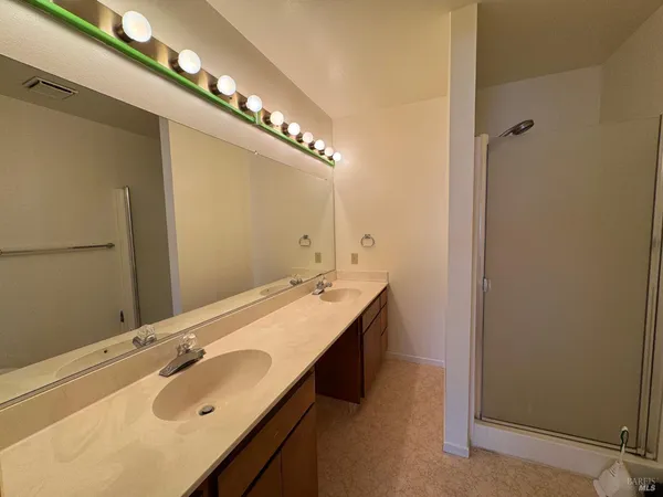 a bathroom with a double vanity sink and a mirror