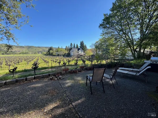 a view of a chairs and table in the back yard