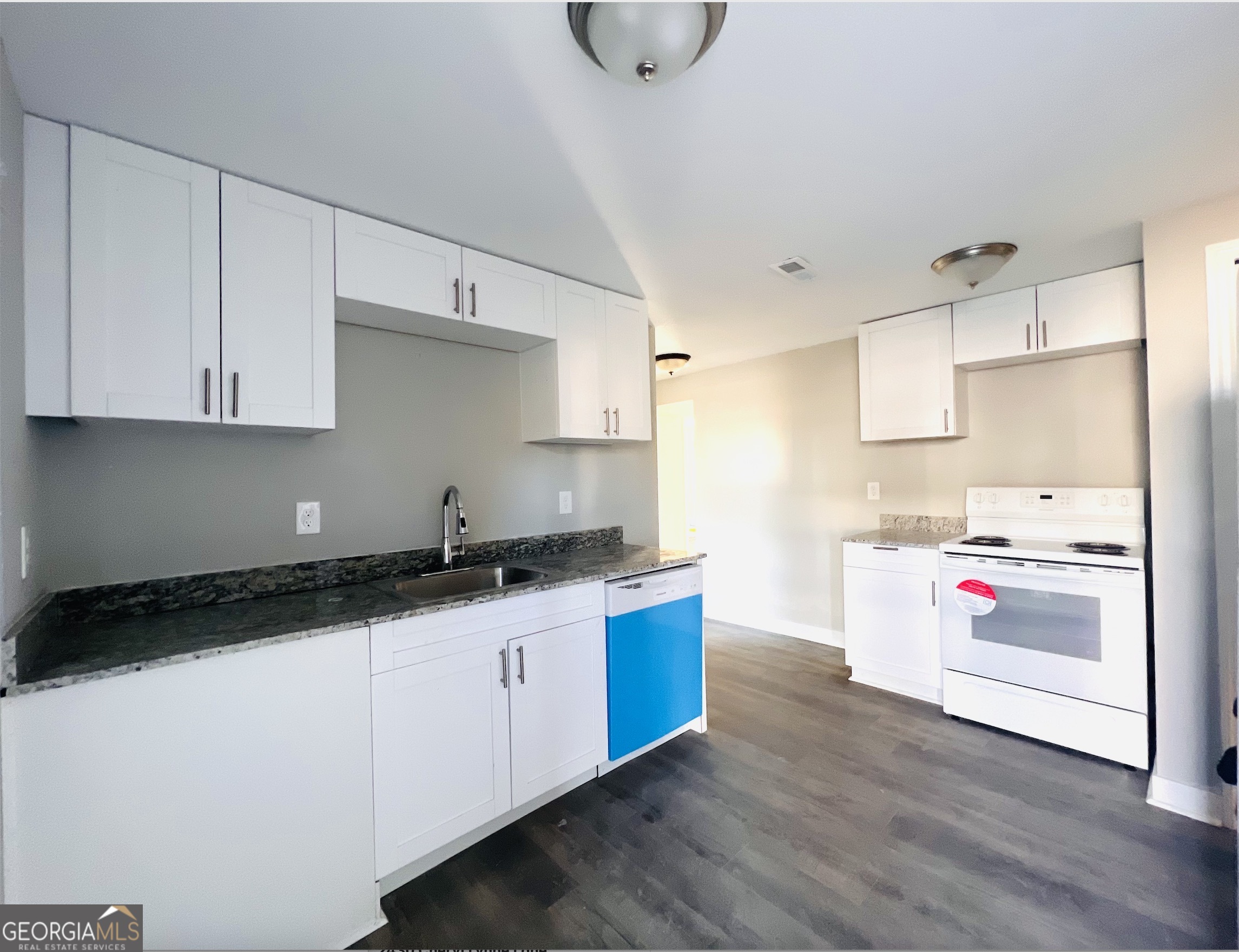 a kitchen with granite countertop a sink and a stove top oven